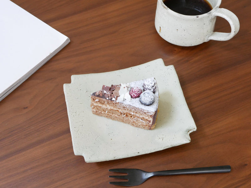 南窯/EDITIONSの手作り荒粉引隅切菓子皿にケーキが盛られた画像