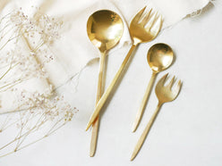 Horn Pleaseブランドの真鍮製スムースカトラリーセット。デザートスプーン、デザートフォーク、ディナースプーン、ディナーフォークが整然と並べられている