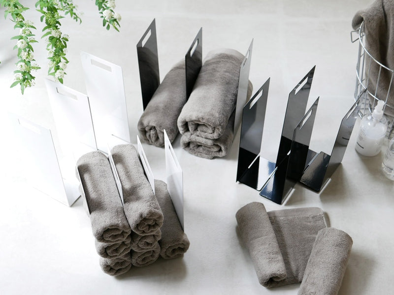 グレーとシルバーのtower連結タオル収納ラックにタオルが掛かっている