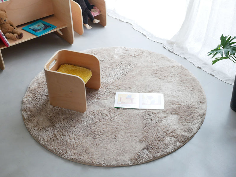 リビングルームのラミネートフローリングに敷かれた直径130cmの円形ポリエステルマイクロファイバーラグ