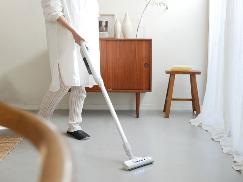 シロカの2WAYコードレススティッククリーナーかるピカパワーが木製フローリング上で掃除に使用されている様子