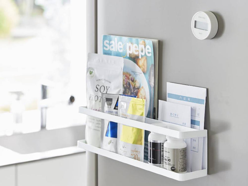 スチール製マグネット冷蔵庫横ラックが壁に設置され、調味料瓶とサプリメントが整然と並べられている様子