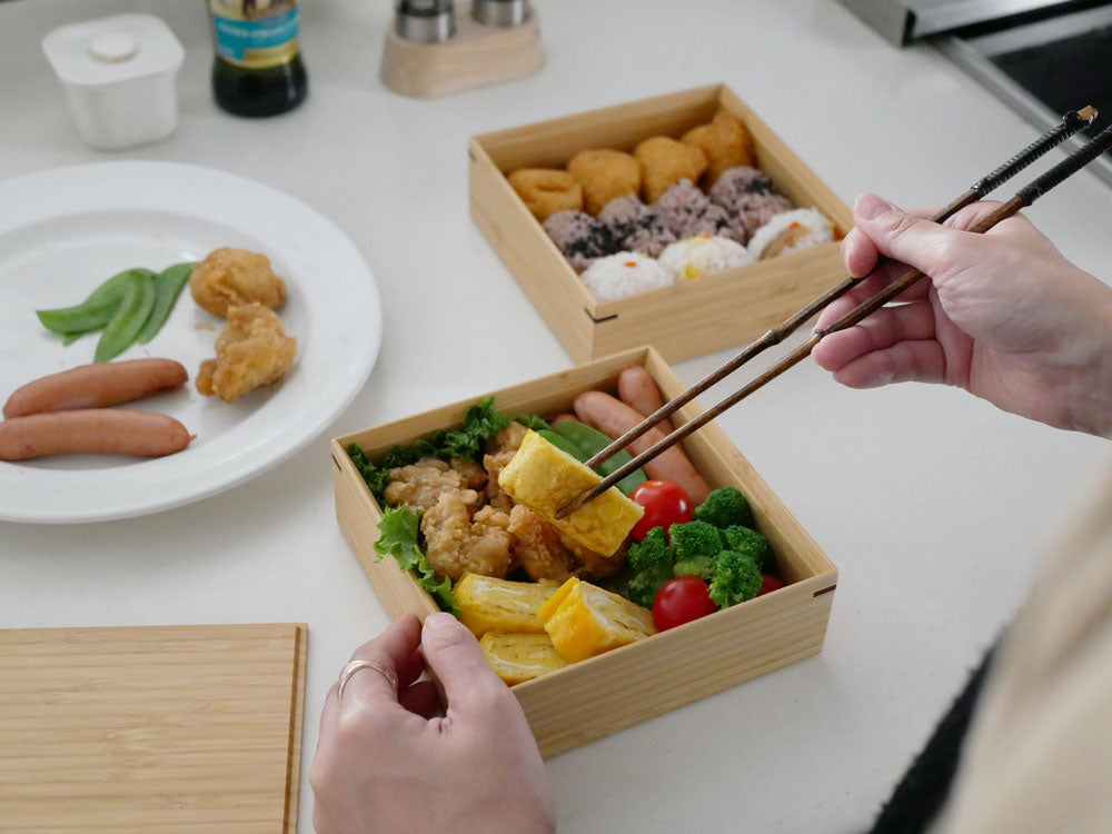 公長斎小菅の黒竹取り箸が美しく配置されたランチセット。自然素材の高品質な箸が食卓を華やかに彩ります。