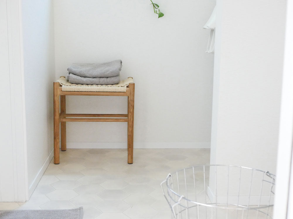 サンフラワーラタン/HOKOSペーパーコード×チークスツールが木製フローリングの上に配置されている様子