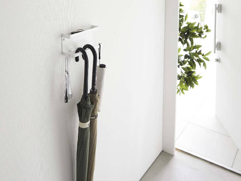 スチール製で石こうボード対応のトレー付きスマートアンブレラホルダー。壁に取り付けられ、耐荷重2kgのバーと1kgのトレーが特徴です