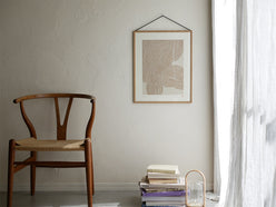 オーク材とブラックアルミニウムのMOEBEフレームが木製床に置かれた静物写真