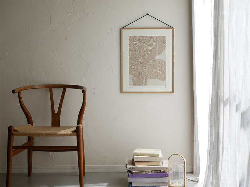 オーク材とブラックアルミニウムのMOEBEフレームが木製床に置かれた静物写真