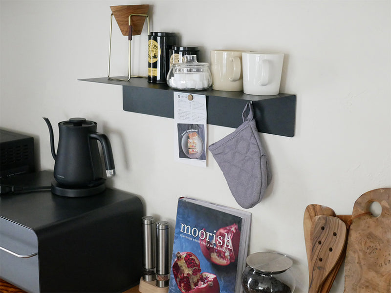 マグネット付きタワーウォールラックに並べられた白と黒の陶器製カップと食器