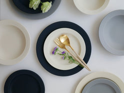 「SAKUZAN」Saraシリーズの日本製磁器プレートとボウルのセット。異なるサイズのディナウェアが美しく並んでいます。