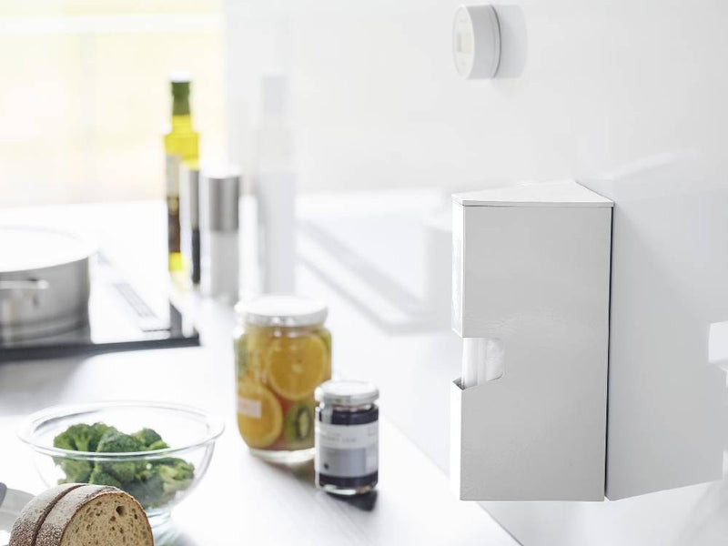 マグネットプラスチックバッグケース タワーがバスルームキャビネットに設置され、シルバーの蛇口やソープディスペンサー、ボトルなどの家庭用品とともに配置されている様子