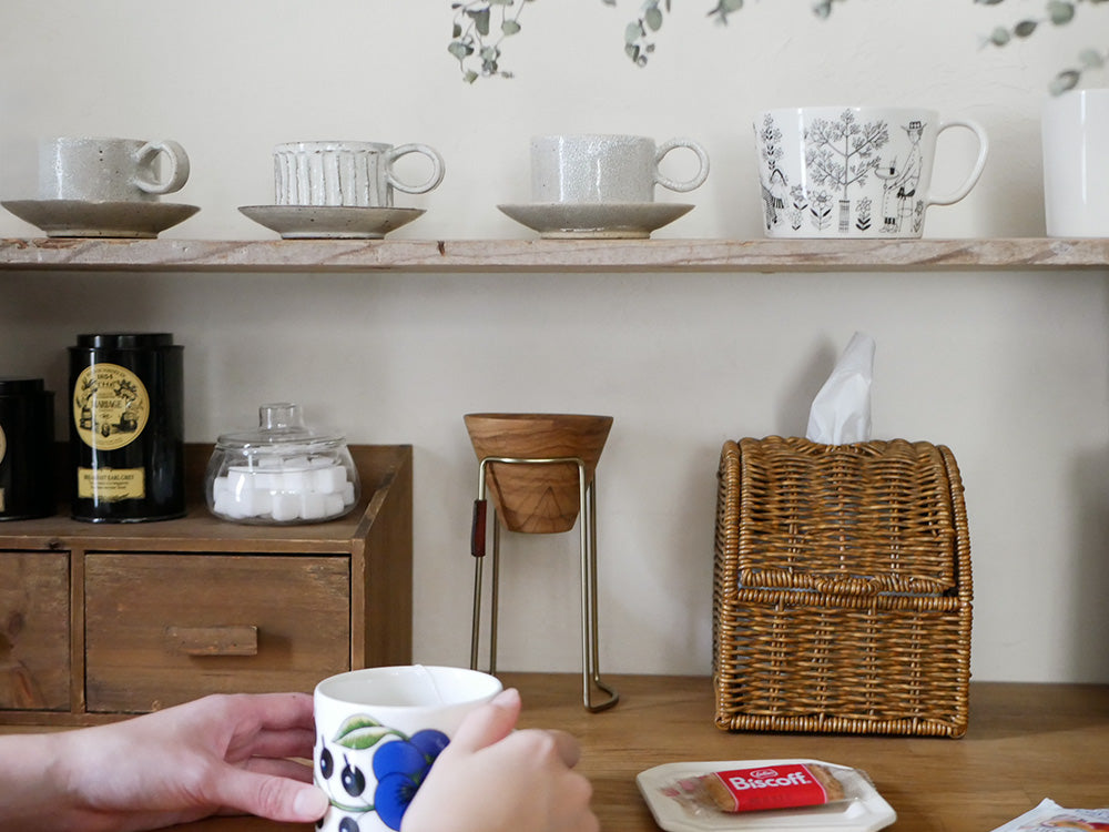 クレエ ユティル洗えるコンパクトティッシュケースと陶器製カップがテーブル上に並べられている様子