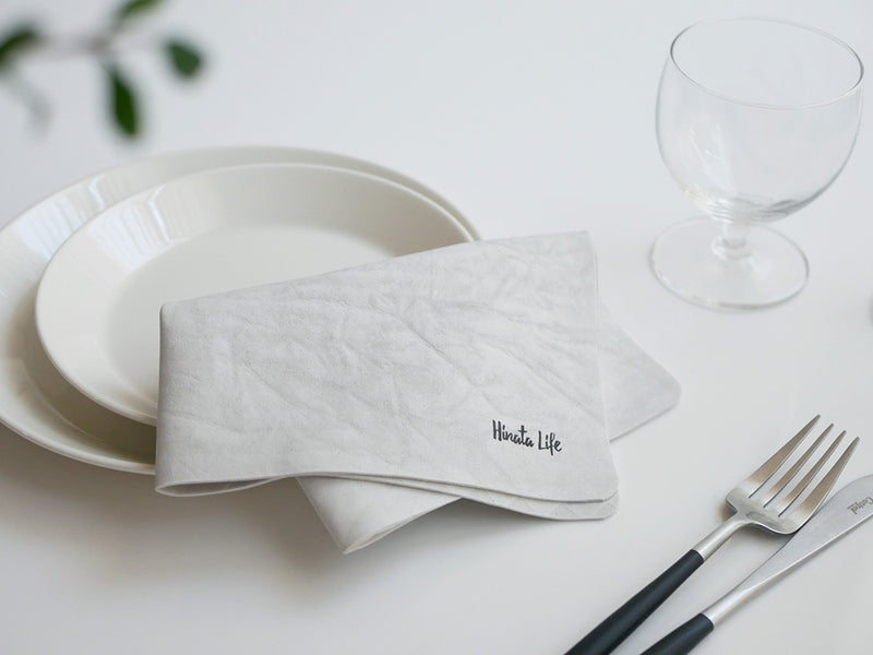 テーブル上にプレート、フォーク、ナプキン、カトラリーなどの食器が整然と並べられている様子