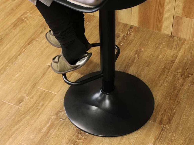 ブラックとアイボリーのNO-FPカウンターチェアが木製フローリング上に配置されています