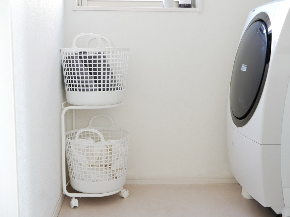 like-itの2段ランドリーバスケットと洗濯機が並ぶ洗濯室