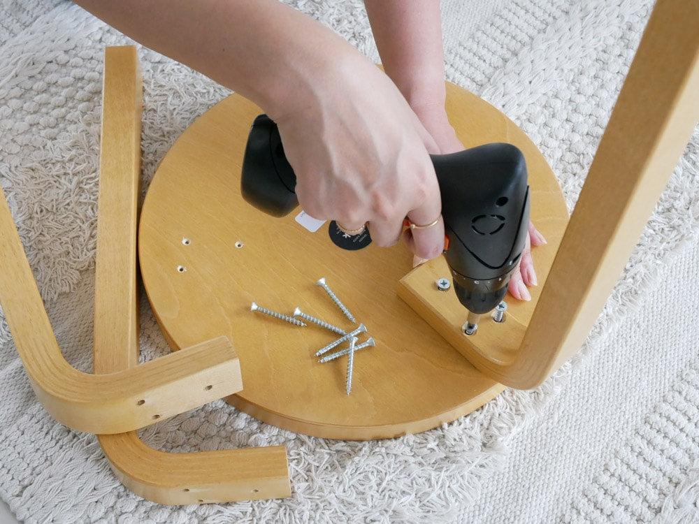 Artekのスツール60バーチがリビングルームの木製フローリング上に置かれている様子