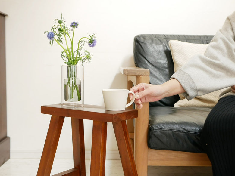 POSH LIVINGのガラス製フロートベースが木製デスクとスツールとともに配置されたモダンな室内インテリア