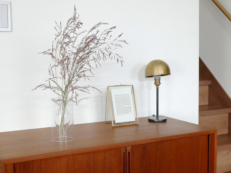 POSH LIVINGのガラス製フロートベースが木製家具や花瓶と調和したモダンな室内インテリアに配置されています