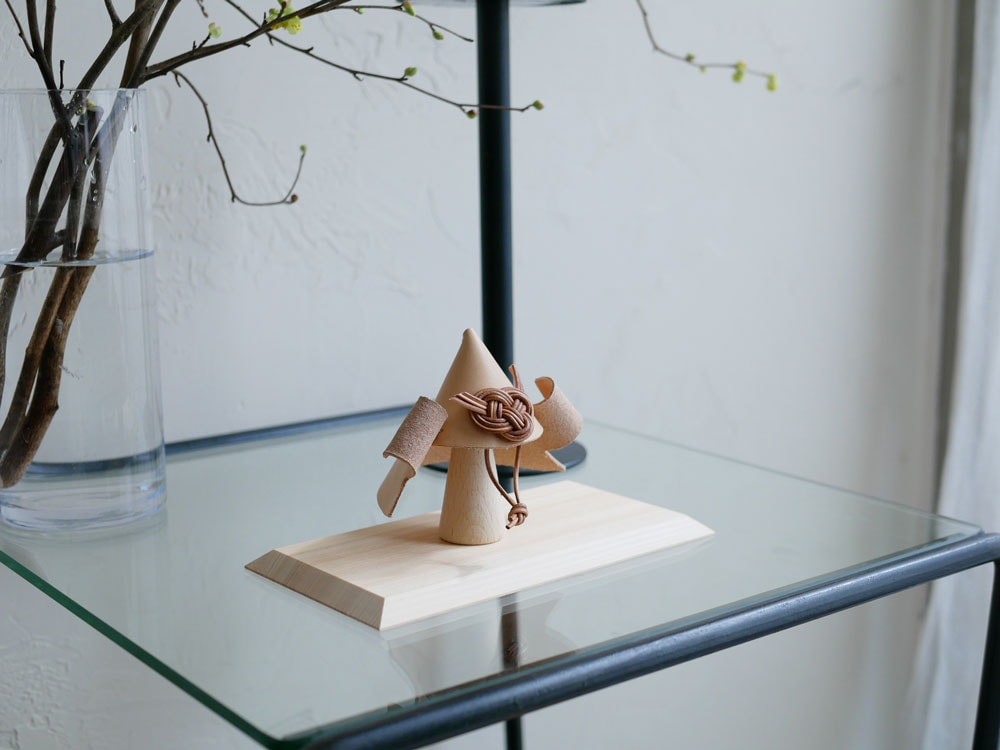 自然素材のヌメ革兜と木製スタンドがバランス良く配置された静物写真