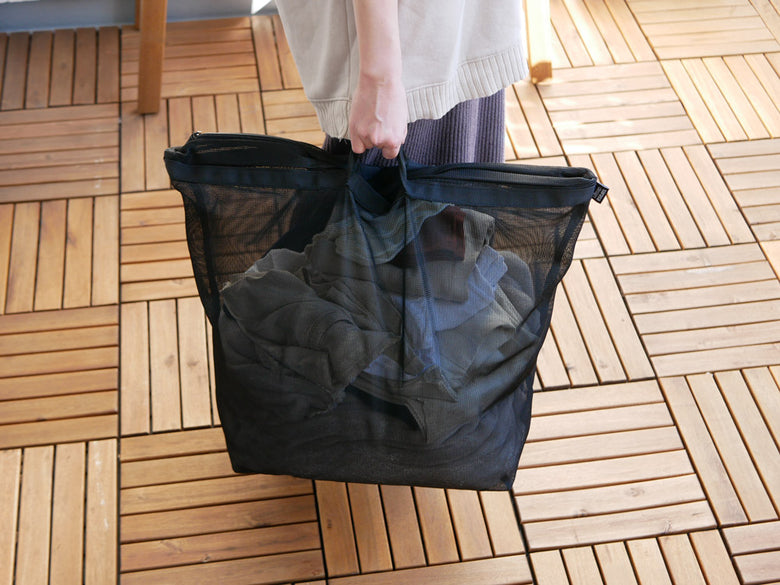サラサデザインのランドリーネット バッグタイプ収納バスケットが木製床の上に置かれている様子