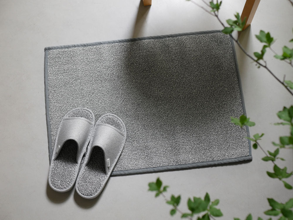 灰色カーペットの上に置かれた銀色のささ和紙スリッパ