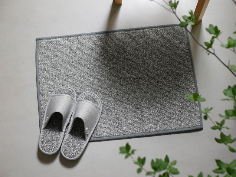 灰色カーペットの上に置かれた銀色のささ和紙スリッパ