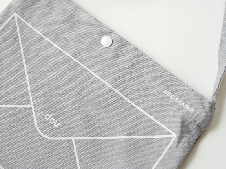 douブランドのABCスタンプセット。グレーとシルバーの三角模様が施された木製カード、アクリルボード、ショルダーバッグが並んでいる画像。