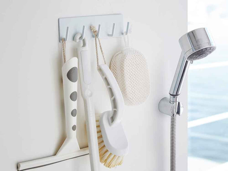 金属製の浴室壁に取り付けられたYAMAZAKI/towerのマグネットバスルームフックにタオルやバス用品が掛けられている様子