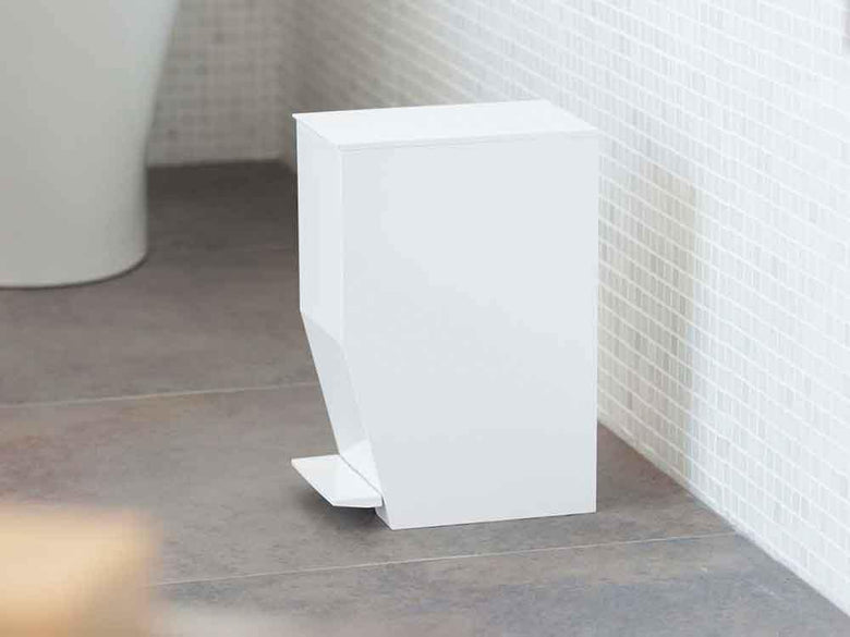 バスルームに設置されたYAMAZAKI/towerのペダル式トイレポット。周囲にはプラスチック製の花鉢やデザインタイルが配置され、モダンな雰囲気を演出しています。