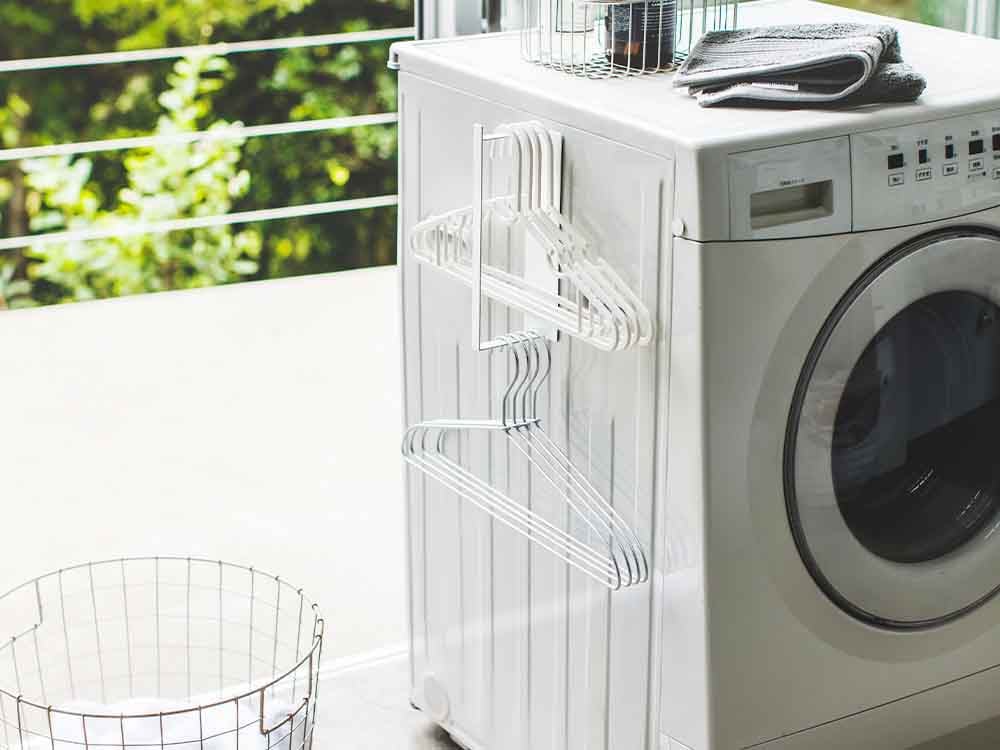 YAMAZAKI/tower製マグネット洗濯ハンガー収納ラック。スチール製の2段式ラックにマグネットとフックが付いており、洗濯室で衣類を整理できます