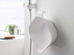 マグネットで壁に固定された浴室用湯おけ