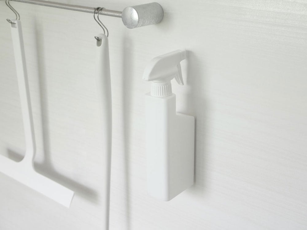 タワーの白いマグネットスプレーボトルが壁に取り付けられている