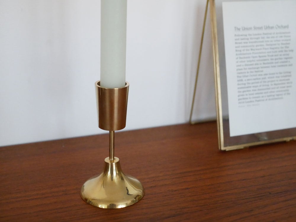 ホーンプリーズメイドの真鍮製キャンドルホルダーに炎が灯ったキャンドル
