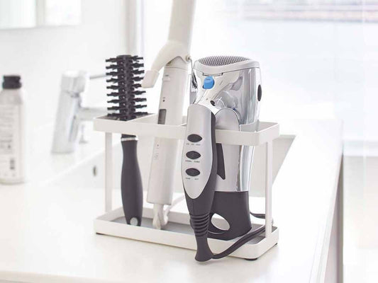YAMAZAKIタワー製シルバーカラーのドライヤー＆ヘアアイロンスタンド。スチールとプラスチック素材を使用し、扉用フックやコード用フックが付属した小型の個人ケア家電用スタンド