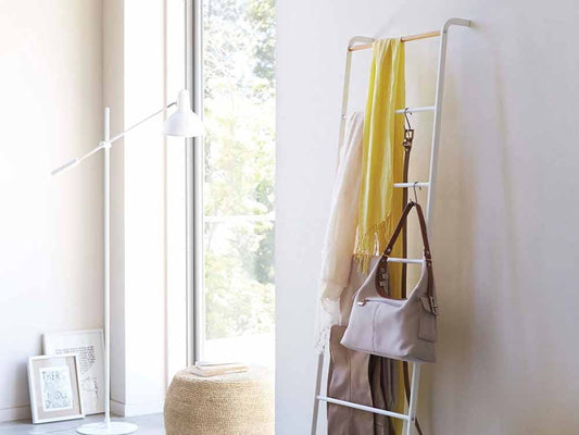 Yamazakiタワー製の木製ラダーハンガーが室内インテリアとして椅子やランプと共に配置されている様子