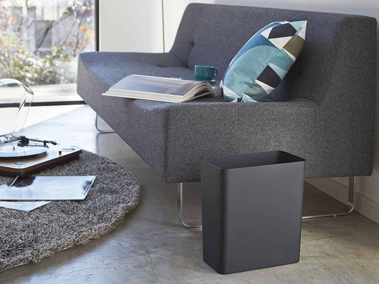 YAMAZAKI/towerブランドの銀色トラッシュカンがリビングルームの木製フローリングの上に置かれている様子