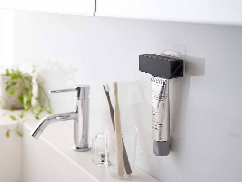 タワー製の歯磨き粉チューブホルダーが洗面台に取り付けられている