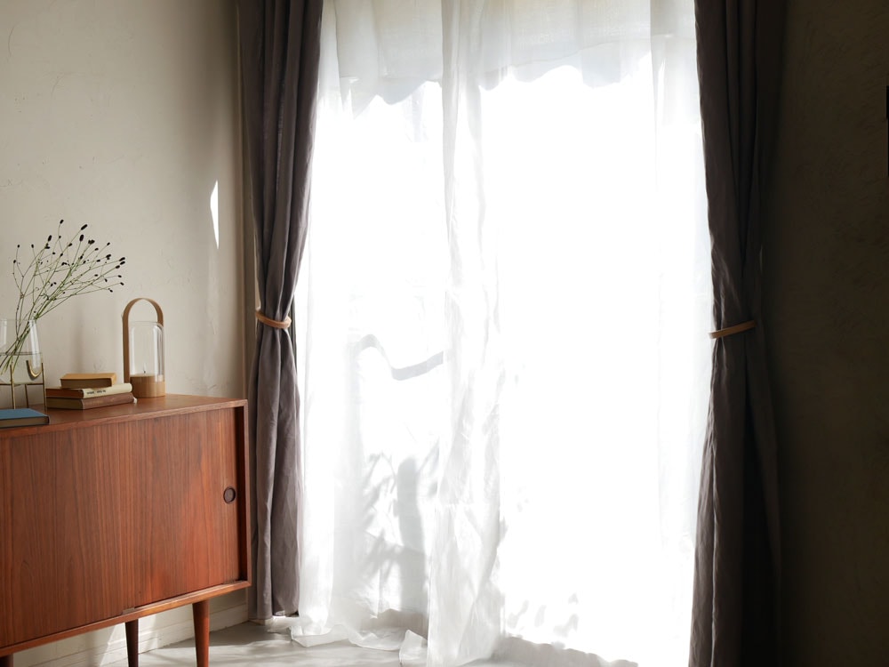 「natsusobikuの100％麻素材ブラウンクリップ留めレースカーテンが窓に飾られた居室のインテリア」