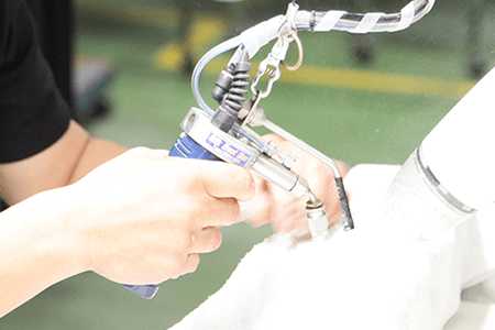 安全手袋をつけた作業員が電動工具を使用