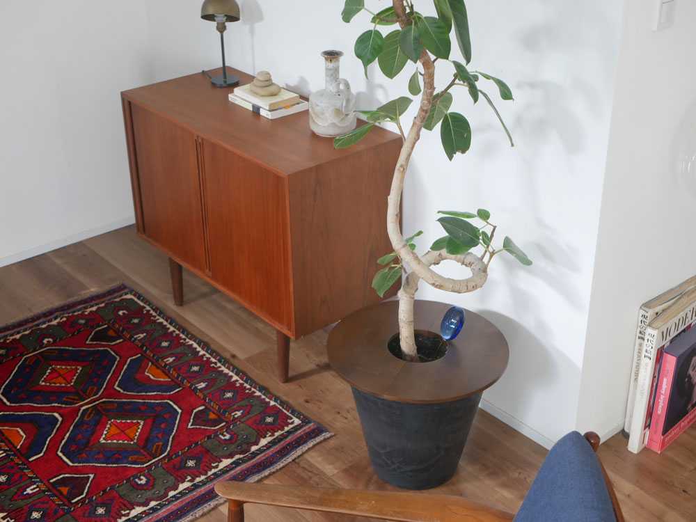 木製の室内用プラントポットとソーサーが配置されたインテリア