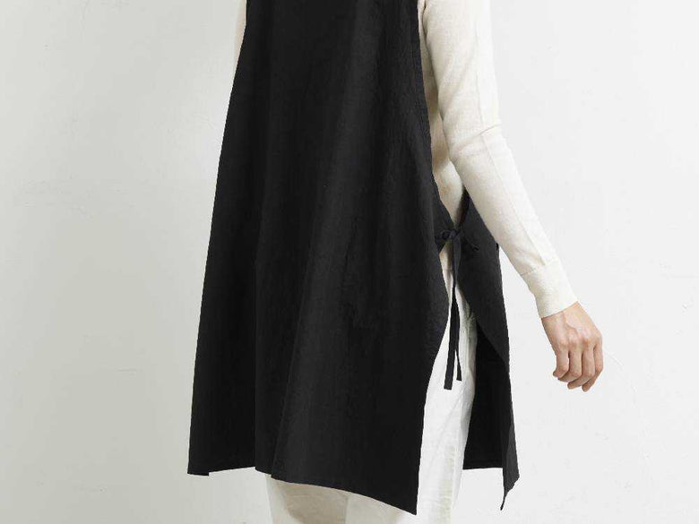 グレーの袖なしビブエプロン