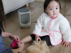 子供がデュクスのミニヒーターの近くで快適に座る姿