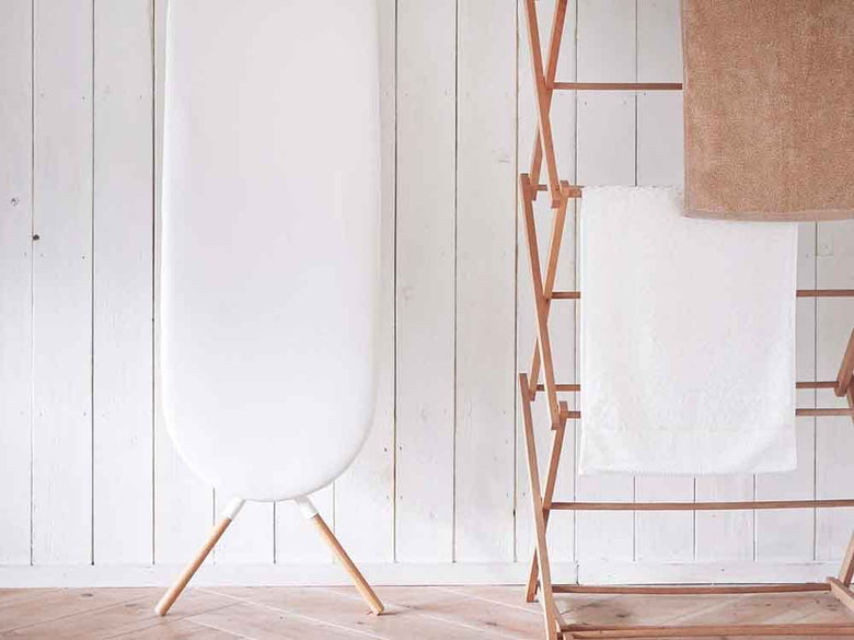 YAMAZAKI/toscaのスタンド式アイロン台。麻・綿の表面布と天然木を使用したスチール製本体が特徴で、幅117cm×奥行36cm×高さ81～53cmのサイズ。