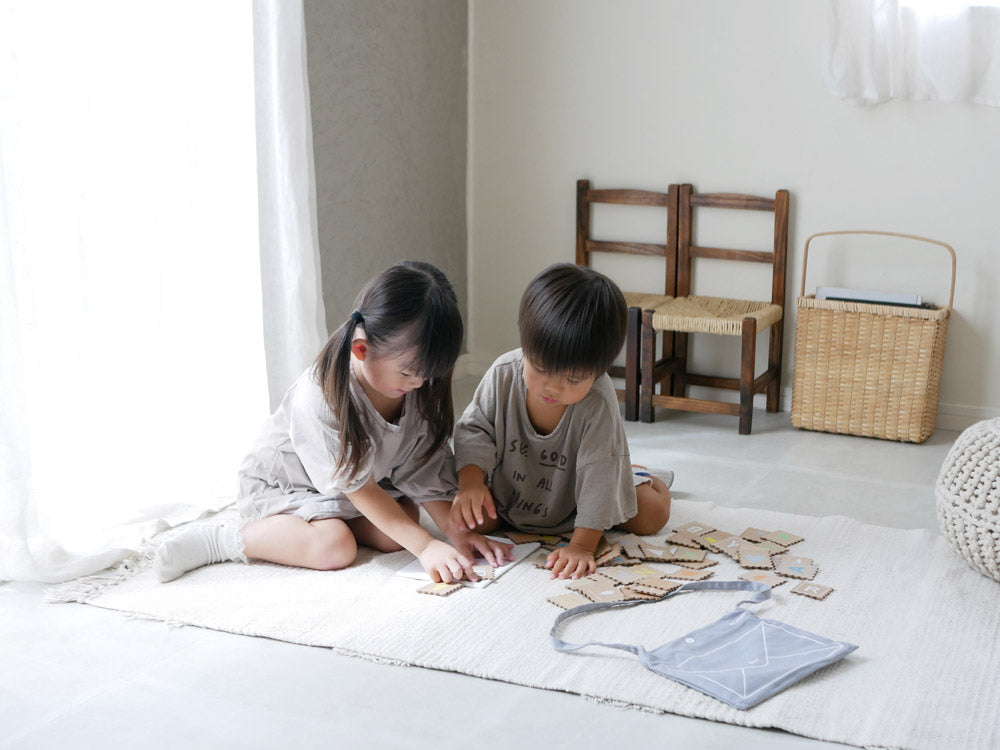 douブランドのABCスタンプセット。MDF木製カード、アクリルボード、綿製ショルダーバッグが木の床の上に並べられている様子