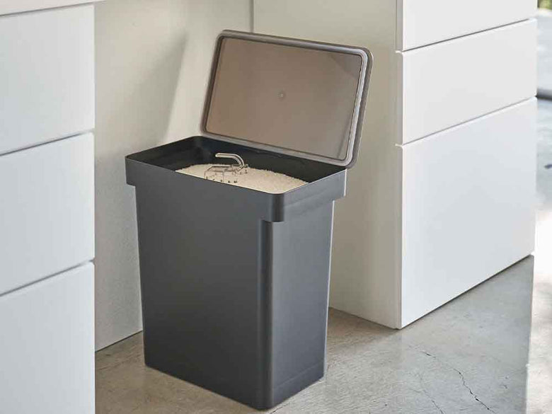 灰色プラスチックの密閉米びつと計量カップ