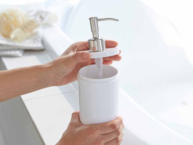 YAMAZAKI製の白色プラスチックソープディスペンサー。シンクに設置された500ml容量のABS樹脂ボトルとステンレスポンプを備えたバスルーム用洗面器。