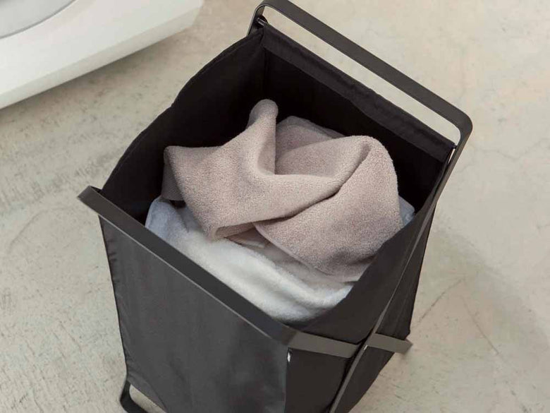 YAMAZAKI/towerブランドの灰色ランドリーバスケット。スチールフレームとプラスチックバスケット、持ち運び用ハンドル付き