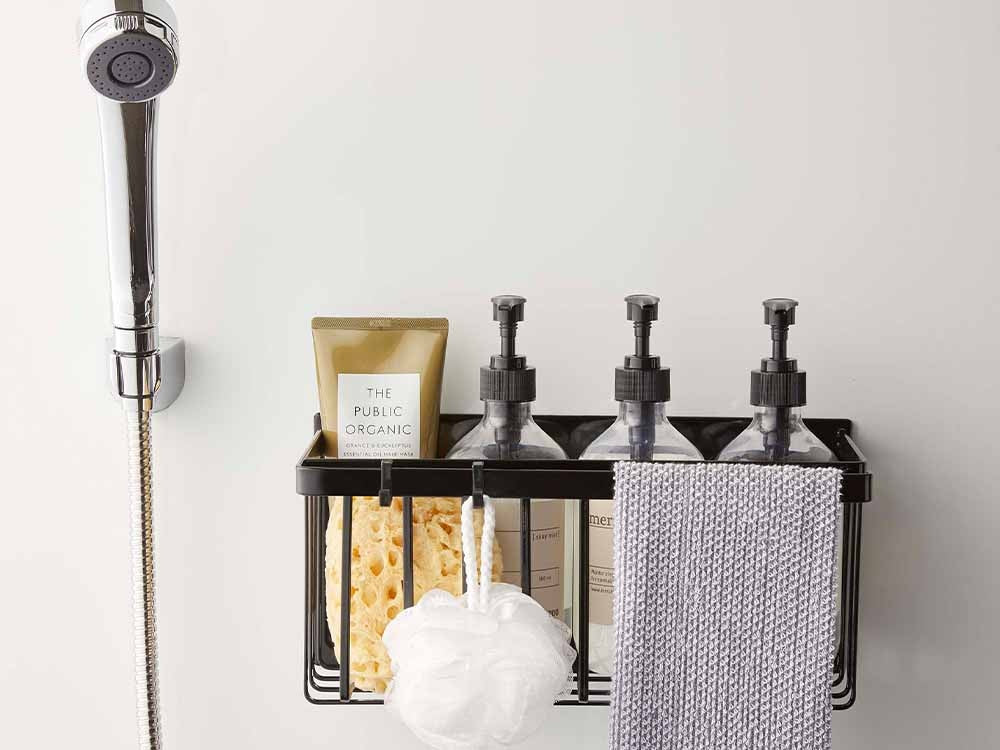 タワーのマグネットバスルームバスケットにタオルや小物が収納されている