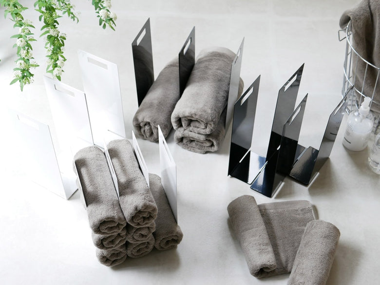 グレーとシルバーのtower連結タオル収納ラックにタオルが掛かっている