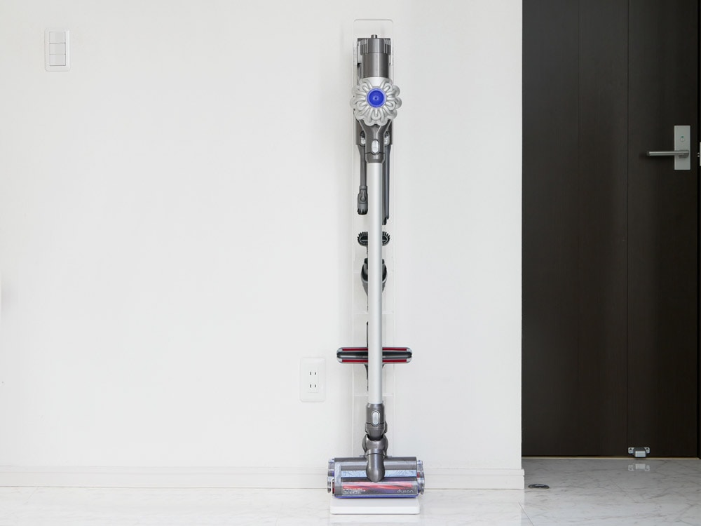 タワー製コードレスクリーナースタンドにダイソン掃除機が壁掛けで固定されている様子