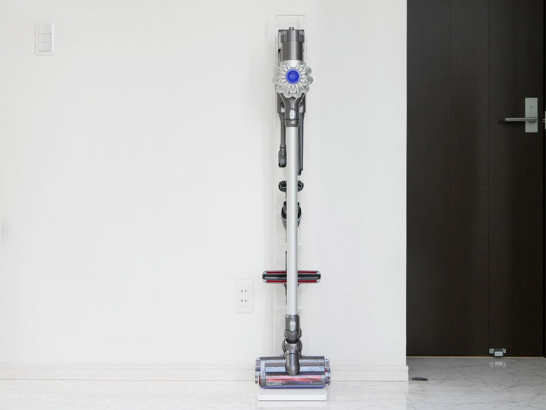 タワー製コードレスクリーナースタンドにダイソン掃除機が壁掛けで固定されている様子